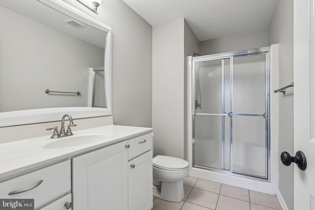 bathroom featuring toilet, vanity, a shower with door, and tile patterned flooring