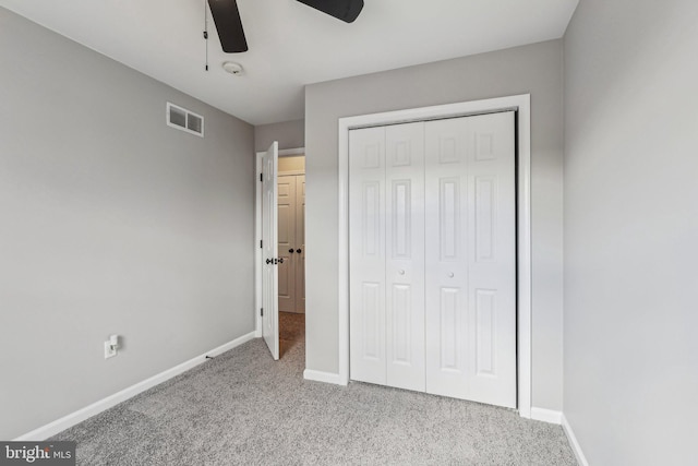 unfurnished bedroom with ceiling fan, a closet, and light carpet