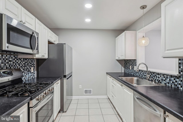 kitchen with sink, white cabinetry, hanging light fixtures, light tile patterned floors, and appliances with stainless steel finishes