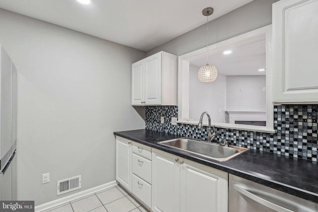 kitchen with pendant lighting, sink, light tile patterned floors, dishwasher, and white cabinetry