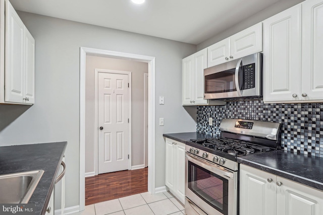 kitchen featuring white cabinetry, stainless steel appliances, and backsplash