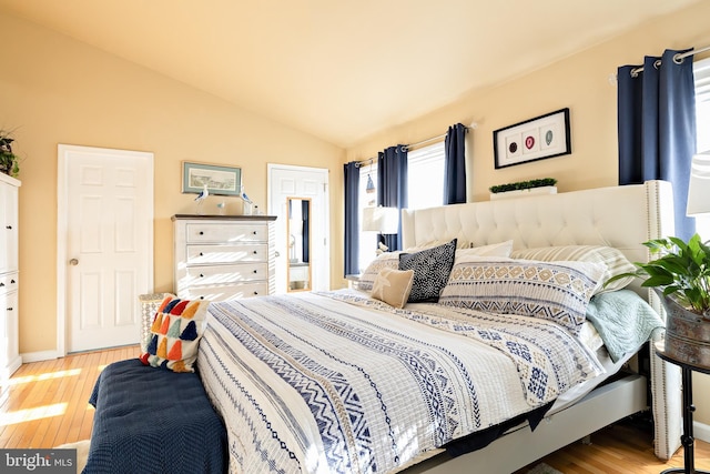 bedroom with lofted ceiling and light hardwood / wood-style floors