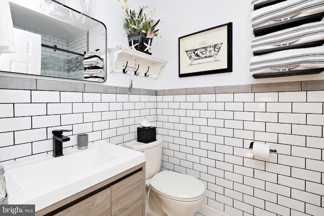 bathroom featuring tile walls, vanity, toilet, and an enclosed shower