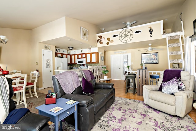 living room featuring lofted ceiling, ceiling fan, and light hardwood / wood-style floors