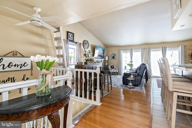 living room with ceiling fan, lofted ceiling, and light hardwood / wood-style flooring