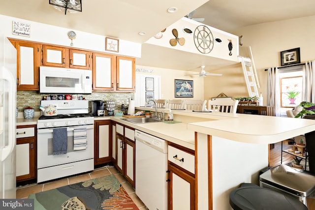 kitchen featuring light tile patterned flooring, sink, tasteful backsplash, kitchen peninsula, and white appliances