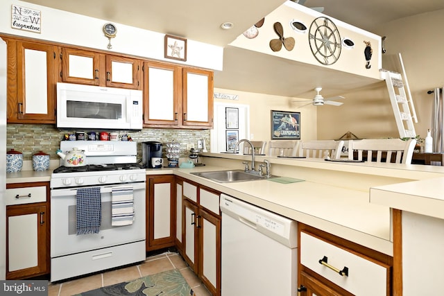 kitchen featuring sink, white appliances, light tile patterned flooring, decorative backsplash, and kitchen peninsula