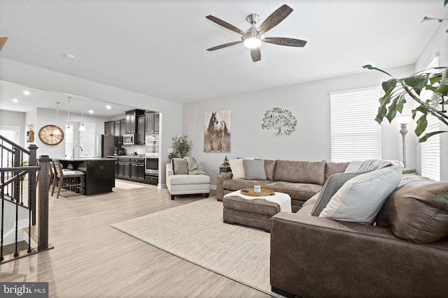 living room with recessed lighting, ceiling fan, light wood finished floors, and stairs