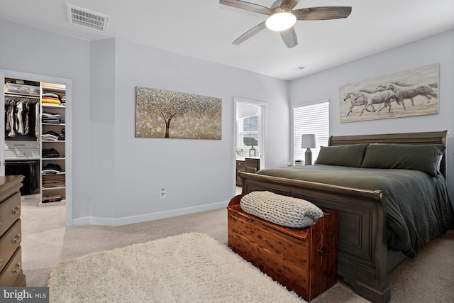 bedroom with baseboards, visible vents, light colored carpet, a spacious closet, and a closet