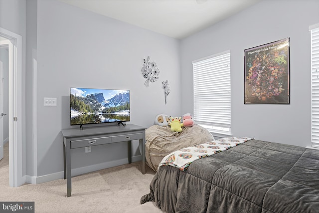 bedroom with light carpet and baseboards