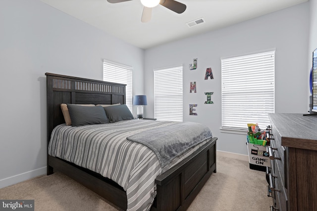 bedroom featuring baseboards, visible vents, a ceiling fan, and light colored carpet