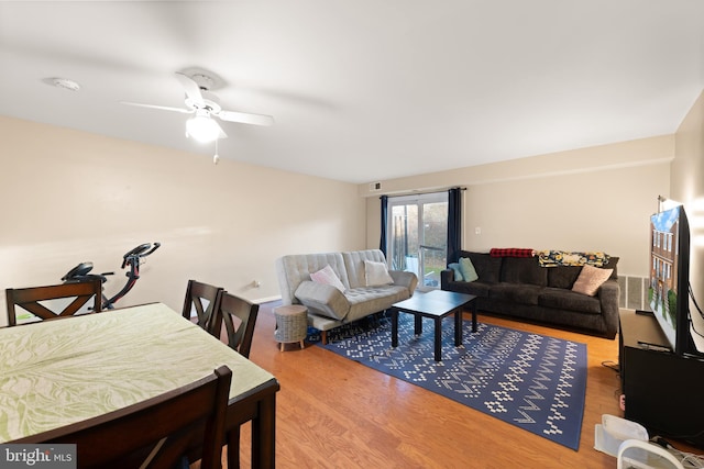 living room featuring wood-type flooring and ceiling fan