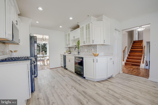 kitchen with glass insert cabinets, light countertops, dishwasher, and white cabinetry