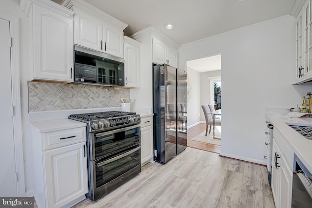 kitchen featuring appliances with stainless steel finishes, light countertops, and white cabinetry