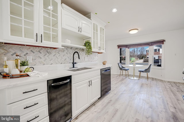 kitchen with glass insert cabinets, a sink, white cabinetry, and decorative backsplash