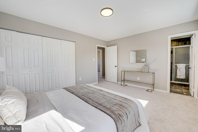 carpeted bedroom featuring baseboards, a closet, and ensuite bathroom