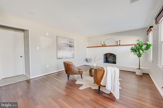 living area featuring a fireplace, wood finished floors, and baseboards