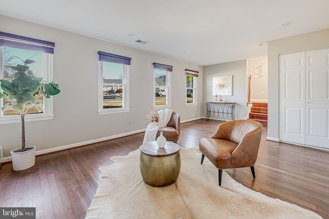 living area with dark wood-type flooring, visible vents, and baseboards