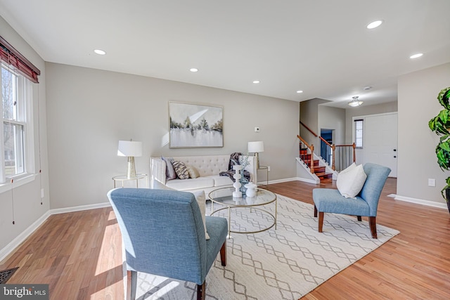 living area featuring light wood-type flooring, stairway, and recessed lighting