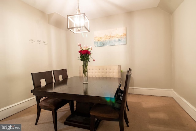 dining space featuring carpet flooring, vaulted ceiling, and a notable chandelier