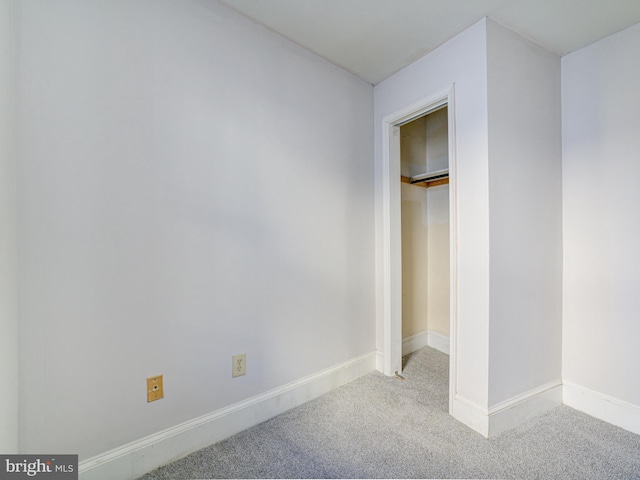 unfurnished bedroom featuring light carpet and a closet