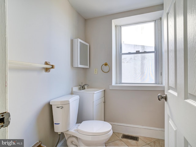 bathroom featuring plenty of natural light, toilet, tile patterned flooring, and vanity