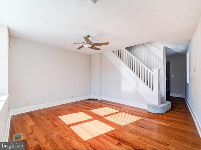 unfurnished living room featuring ceiling fan and hardwood / wood-style floors