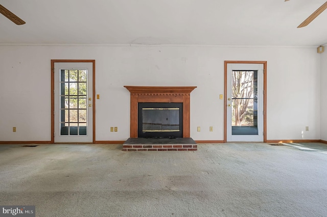 unfurnished living room featuring a fireplace, plenty of natural light, and carpet