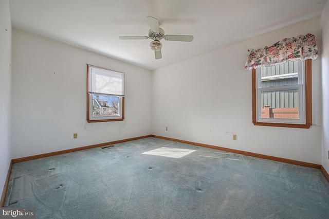 carpeted spare room featuring ceiling fan