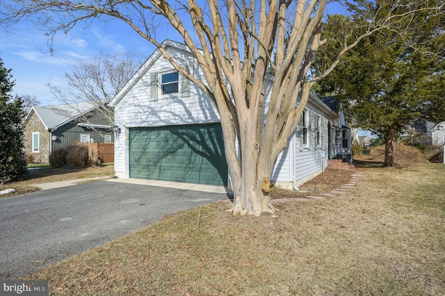 view of front of home featuring a garage, an outdoor structure, and a front lawn