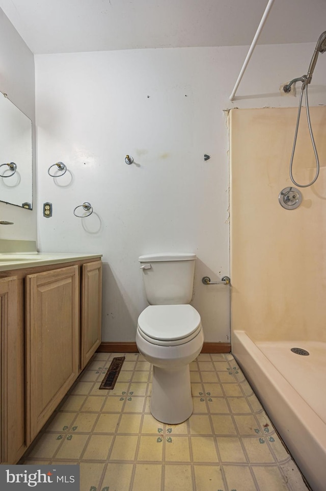 bathroom with vanity, toilet, and a shower