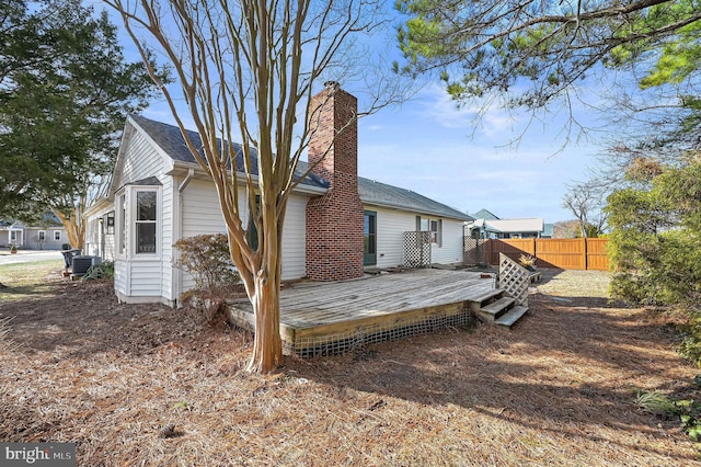 rear view of property featuring a wooden deck and cooling unit