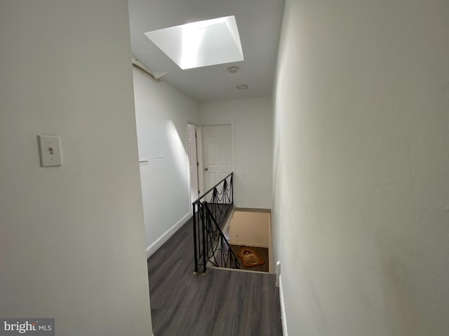 stairs with hardwood / wood-style floors and a skylight