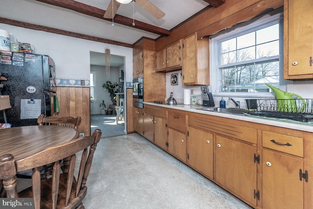 kitchen with ceiling fan, beam ceiling, and black appliances