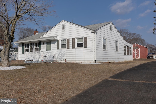 view of front of property with an outdoor structure and covered porch