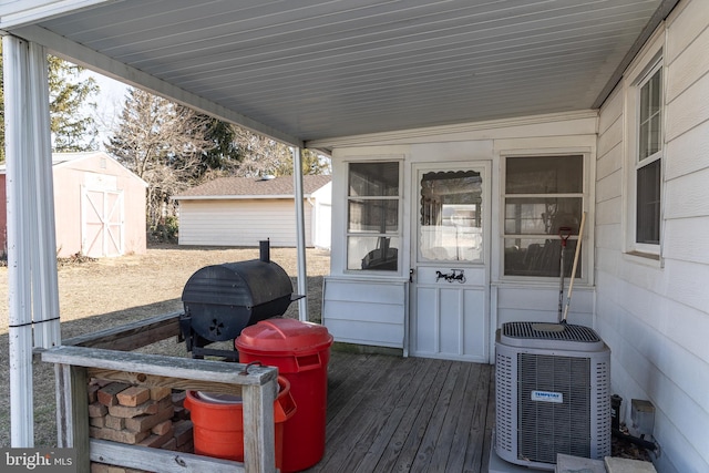 wooden terrace featuring a storage shed and central air condition unit