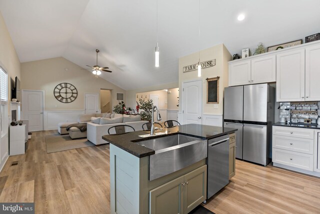 kitchen featuring sink, white cabinetry, a center island with sink, stainless steel appliances, and light hardwood / wood-style floors