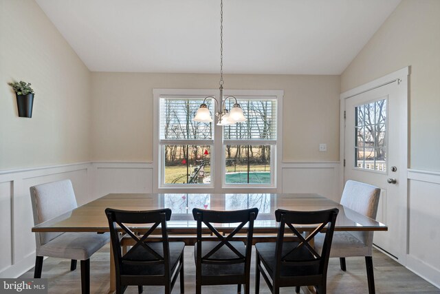 dining room with vaulted ceiling, an inviting chandelier, hardwood / wood-style floors, and breakfast area