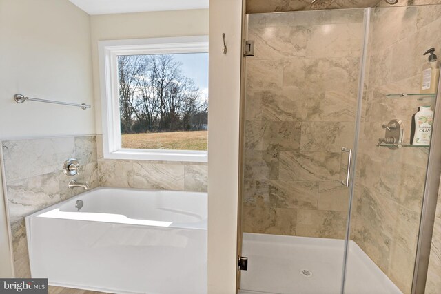 bathroom featuring separate shower and tub