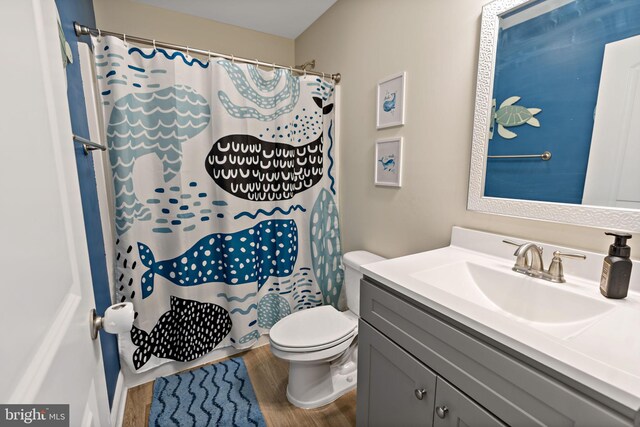 bathroom featuring vanity, hardwood / wood-style flooring, toilet, and a shower with shower curtain