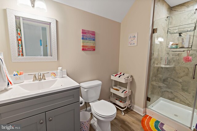 bathroom with an enclosed shower, hardwood / wood-style floors, vanity, and toilet