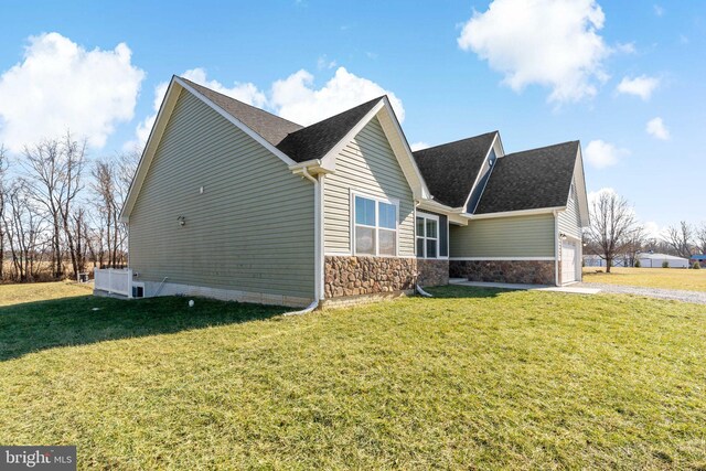 view of side of property featuring a garage and a yard