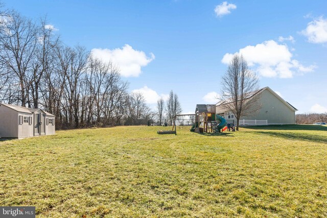 view of yard with a storage shed and a playground