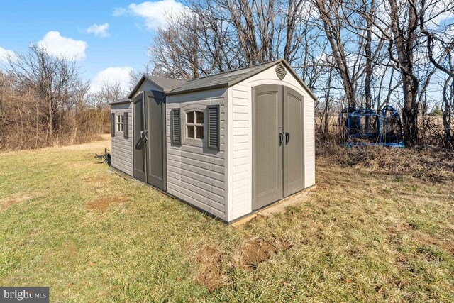 view of outbuilding featuring a lawn