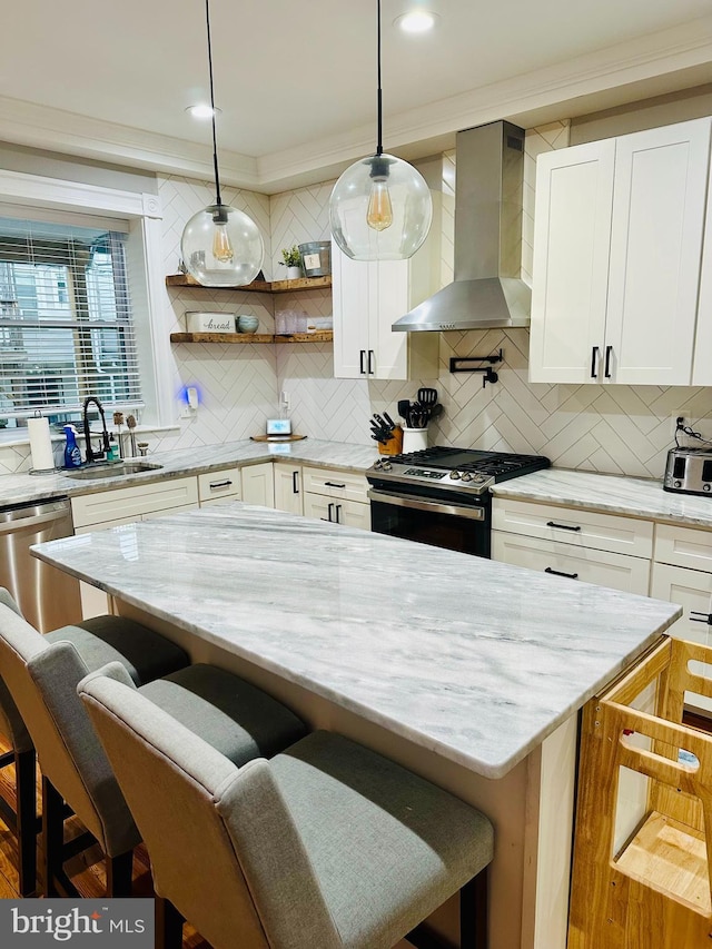 kitchen with appliances with stainless steel finishes, light stone countertops, a breakfast bar area, and wall chimney range hood