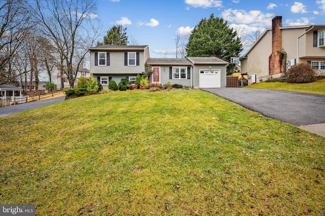 split level home with a garage and a front lawn