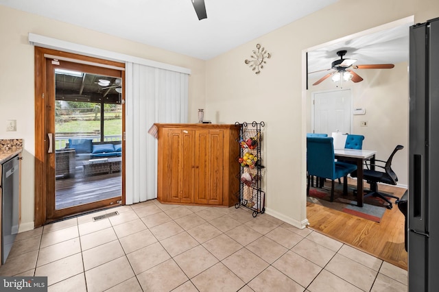 doorway with ceiling fan and light tile patterned floors