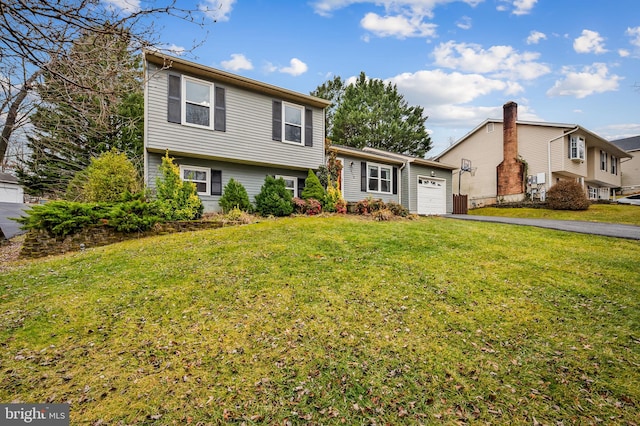 tri-level home featuring a garage and a front yard