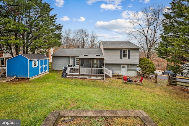 back of property with a storage shed, a wooden deck, a sunroom, and a lawn