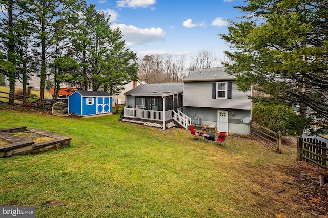 back of property with a sunroom, a yard, and a storage shed